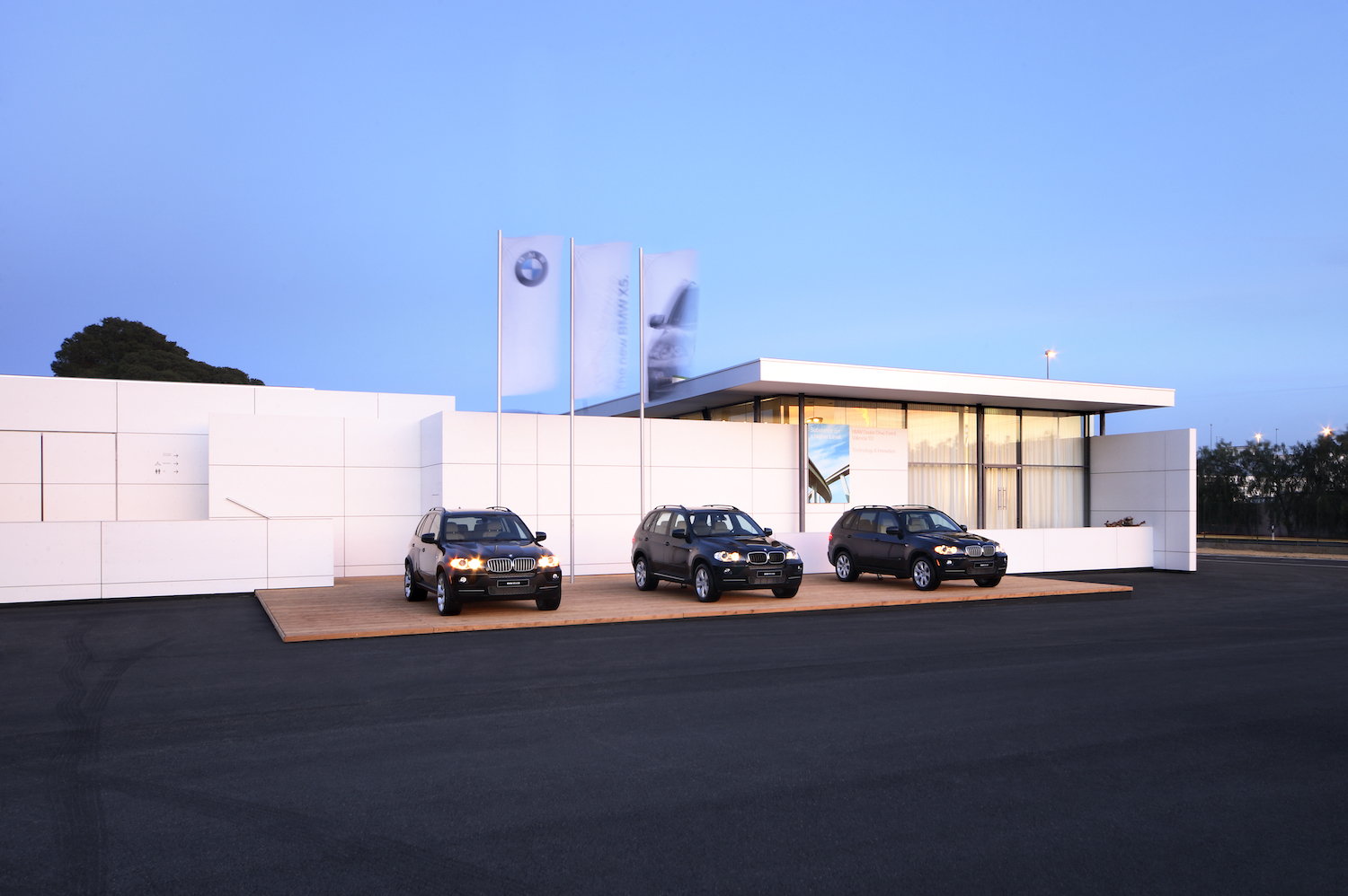 Drei BMW Autos sind vor einer weissen vorgehängte hinterlueftete Fassade geparkt