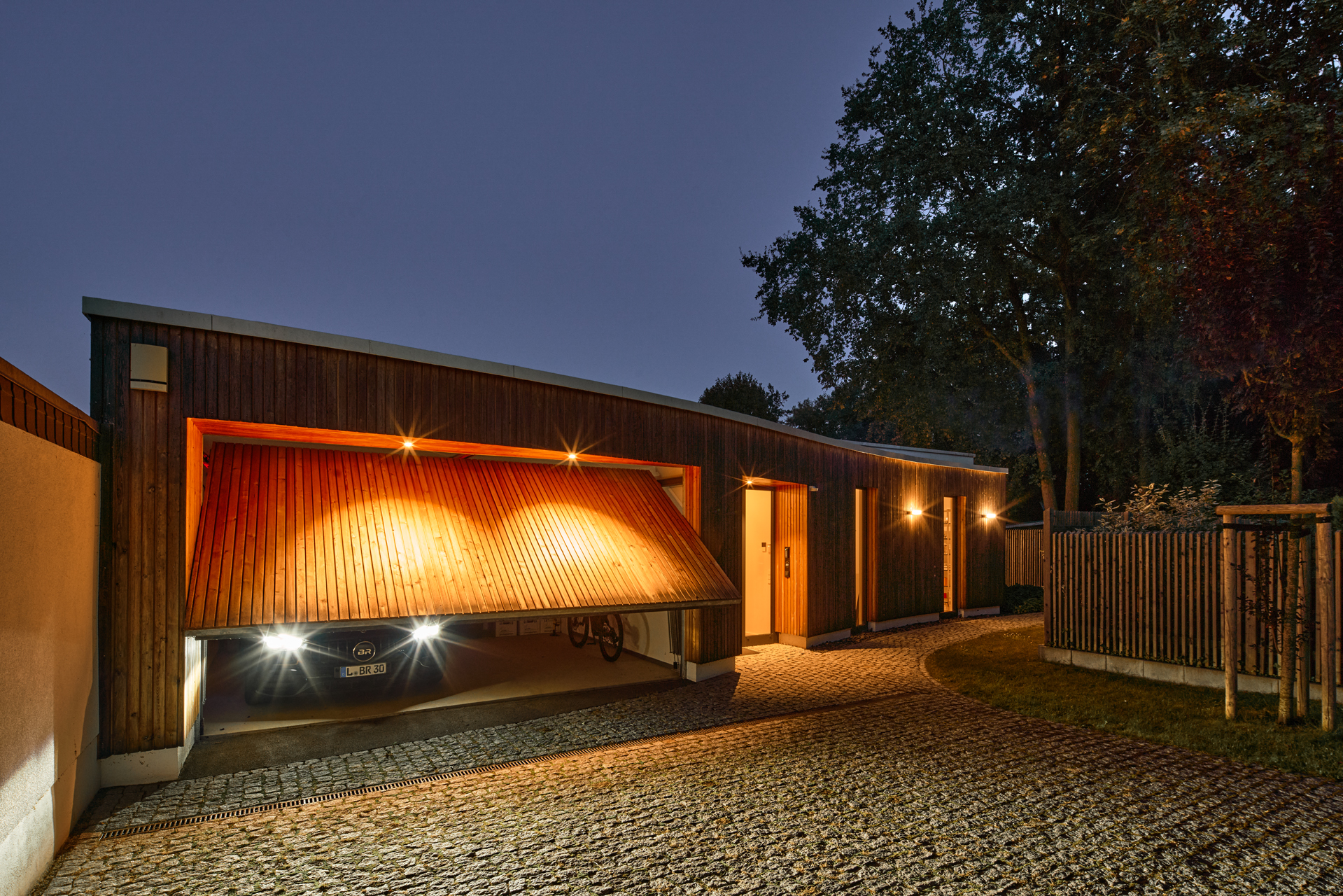 Villa Riva - Wohnbau mit Holzfassade Garage nachts