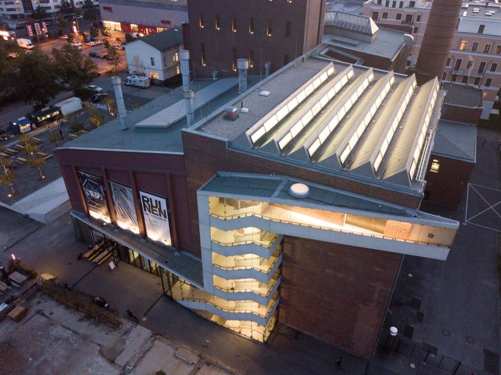 Luftaufnahme des beleuchteten Treppenhauses und der Lichtdächer der KINDL-Brauerei in Berlin
