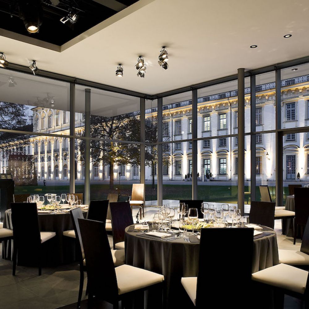 Speisesaal im Inneren des BMW Kubus-Pavillons mit Glasfassade abends
