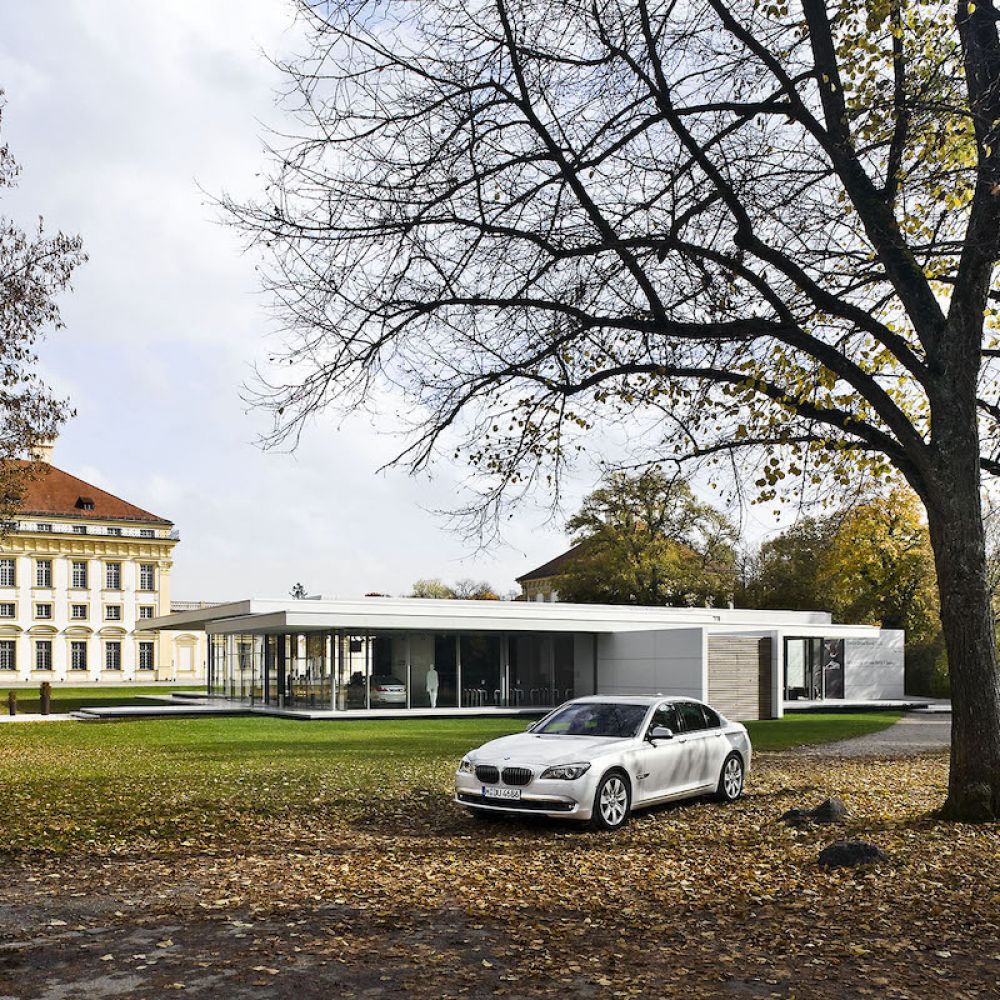 Kubus Pavillon mit Glasfassade und BMW Auto vorne
