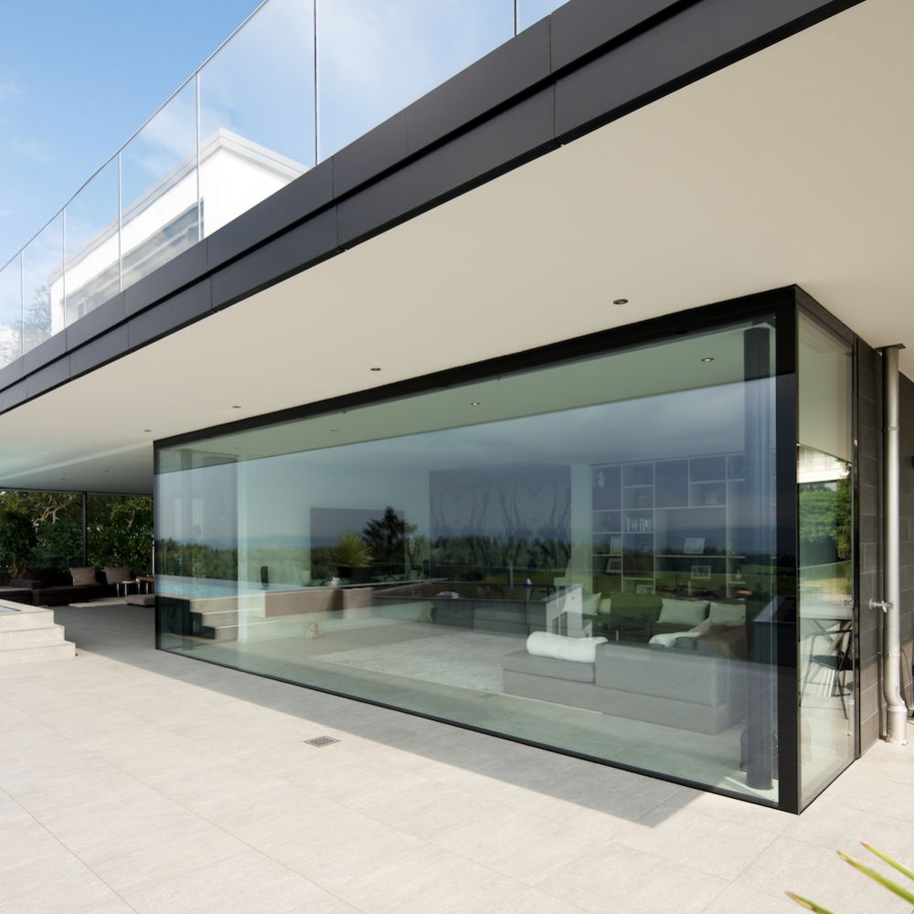Übergrosse Panoramaverglasung von moderner Villa mit Pool und Terrasse