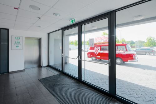 Innenaufnahmen von die Ausgangstüren im Windfang des Erdgas Sportpark in Halle. Draußen hinter der Tür steht das offizielle rote Fahrzeug des Fußballvereins. 