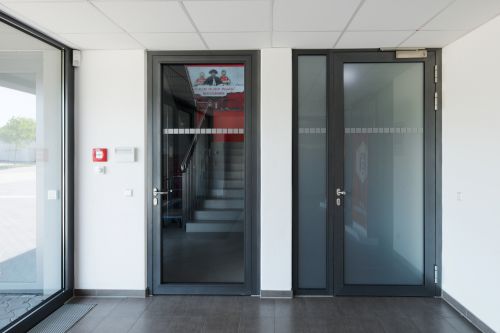 Zwei Brandschutztüren mit Glas stehen nebeneinander im Windfang vom Erdgas Sportpark in Halle.