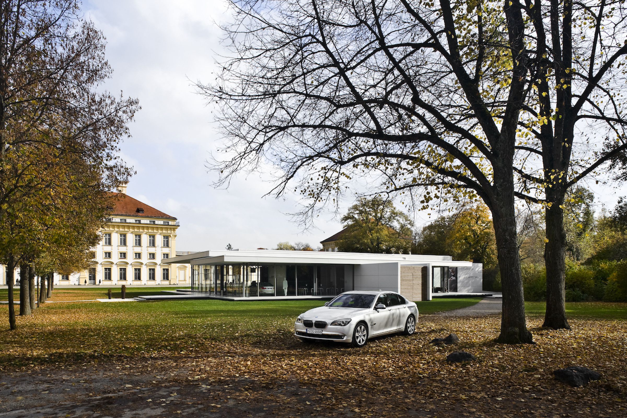 Kubus Pavillon mit Glasfassade und BMW Auto vorne